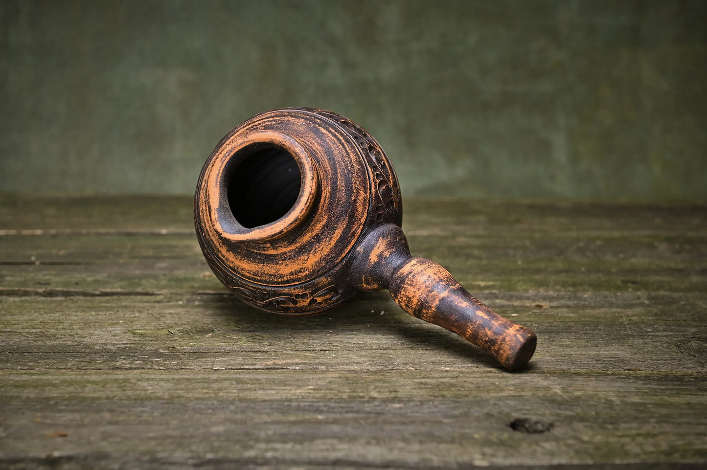 Handmade clay incense burner with carved details, rustic brown glaze, artisan-crafted home decor on wood