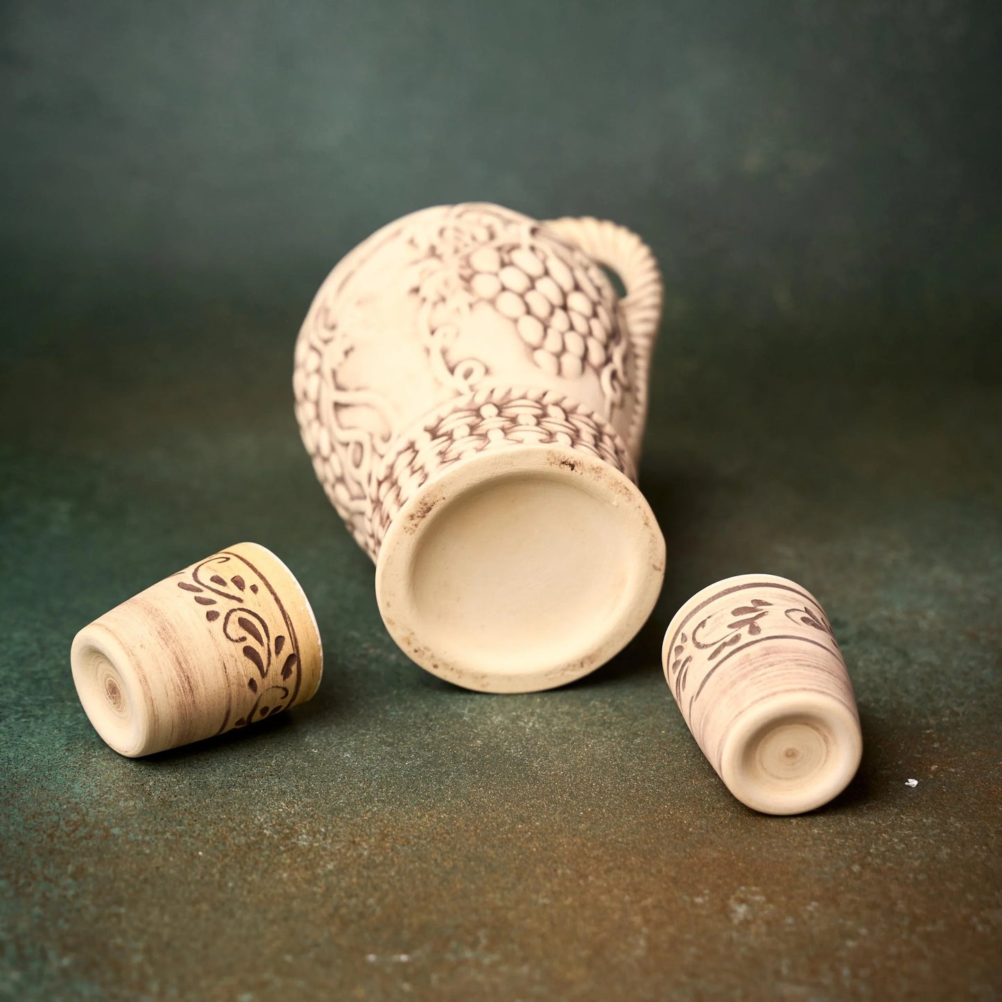 Handmade clay pitcher and cups with intricate etched patterns, artisan-crafted homeware for rustic décor