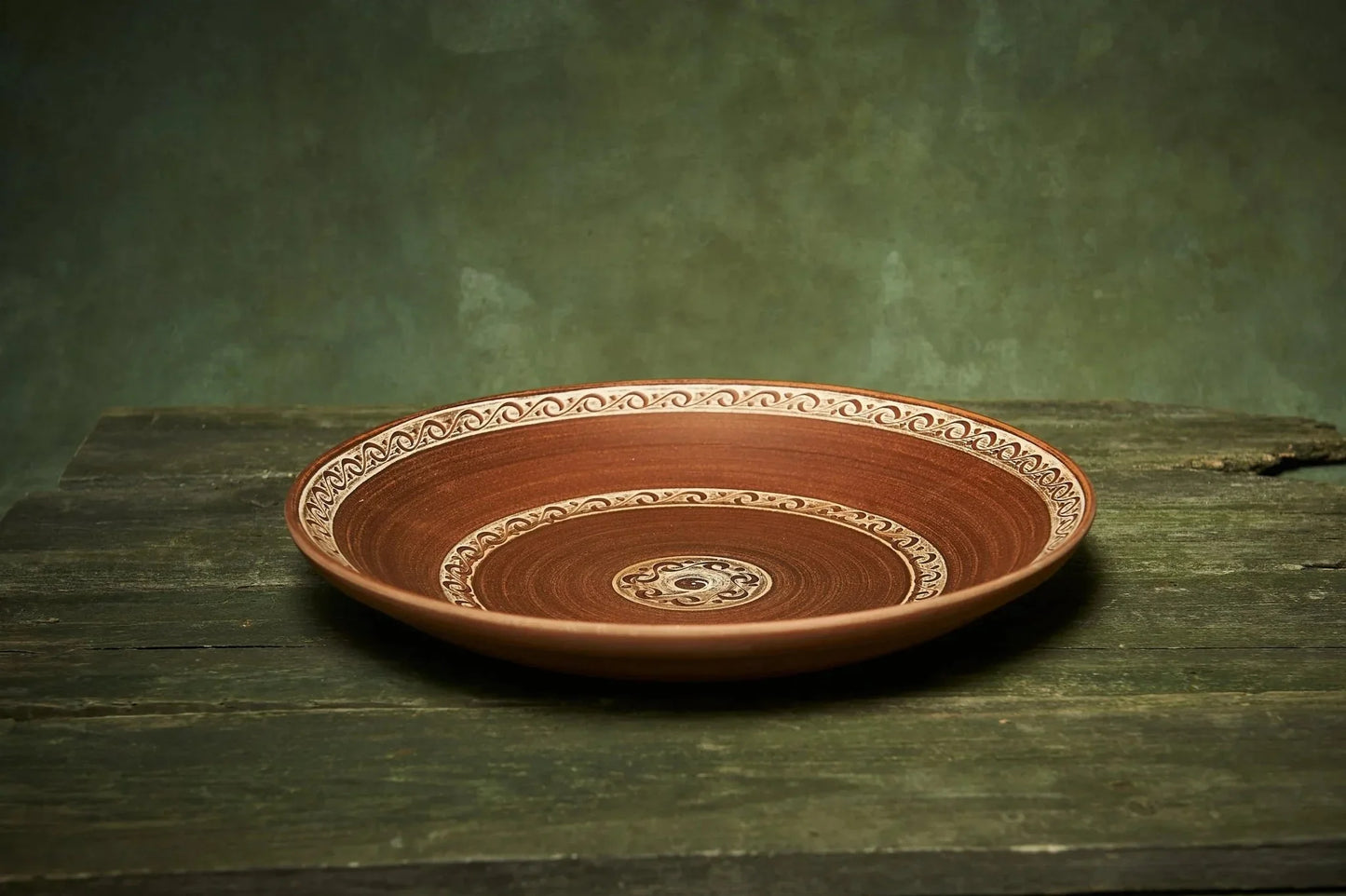 Handmade ceramic fruit plate with intricate patterns, large pottery serving platter on rustic wood