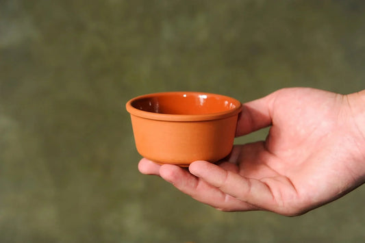 Hand holding handmade terracotta clay bowl, small pottery homeware from clayproductsshop