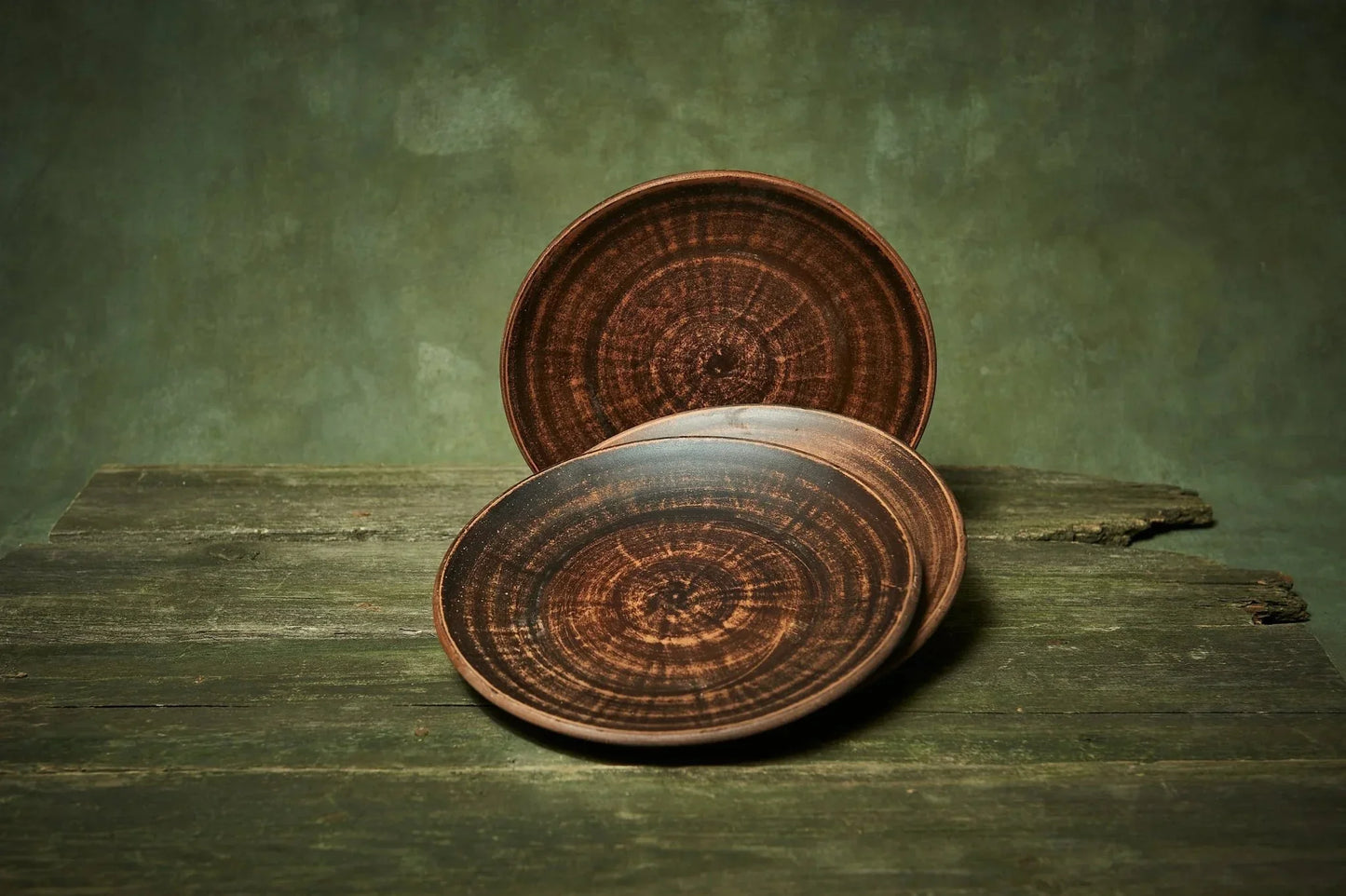 Handmade ceramic plate set of 3, dark clay pottery with rustic finish on wooden surface