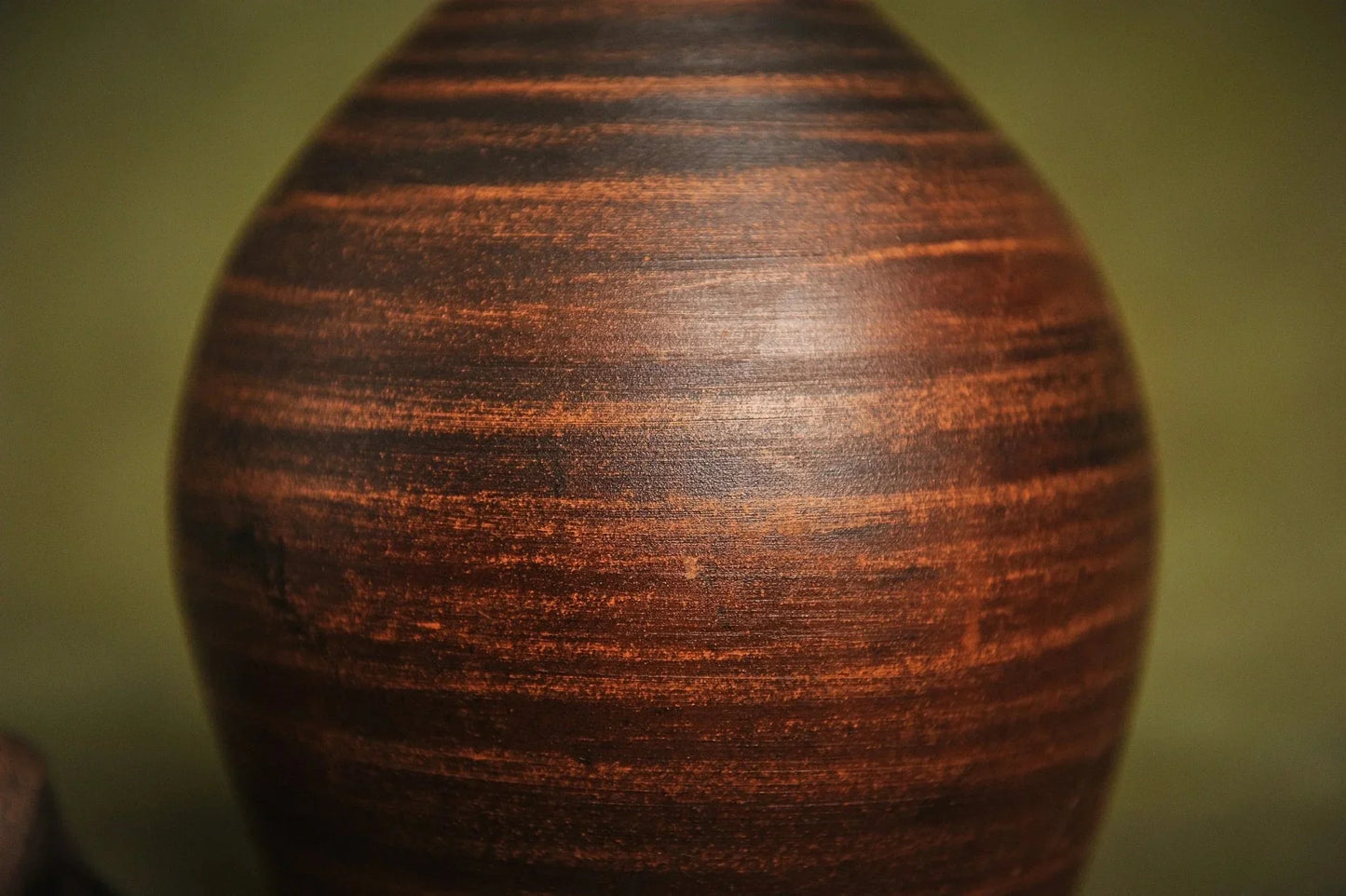 Close-up of handmade red clay jug with natural textured surface, artisan pottery home décor