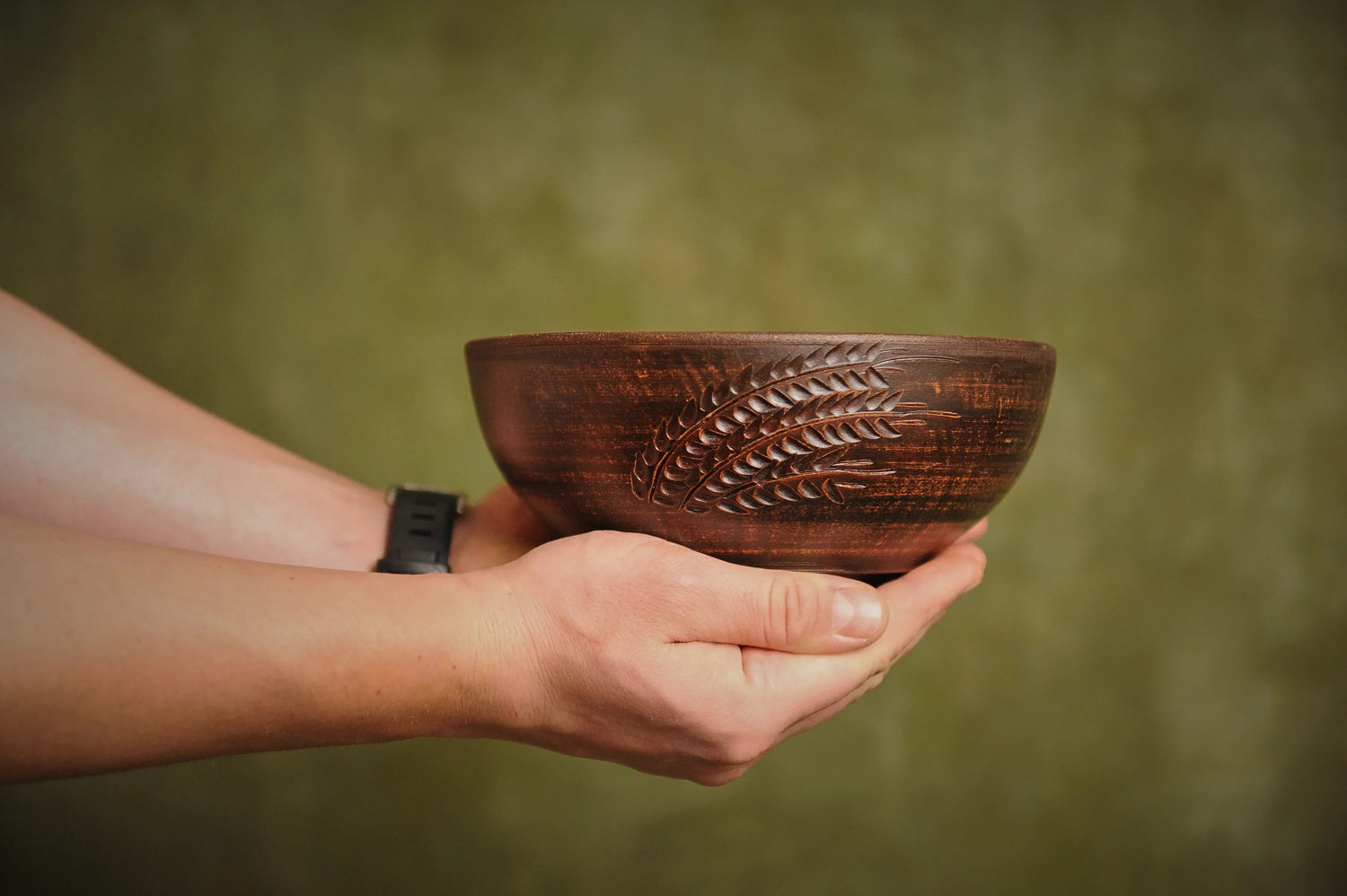 Hand holding a handmade ceramic clay bowl with leaf pattern, artisan homeware from clayproductsshop
