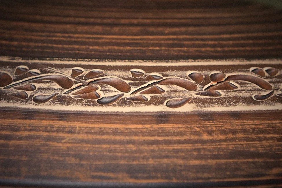 Handmade clay cooking pot with carved floral pattern, rustic artisan kitchenware