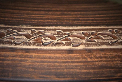 Handmade clay cooking pot with carved floral pattern, rustic artisan kitchenware