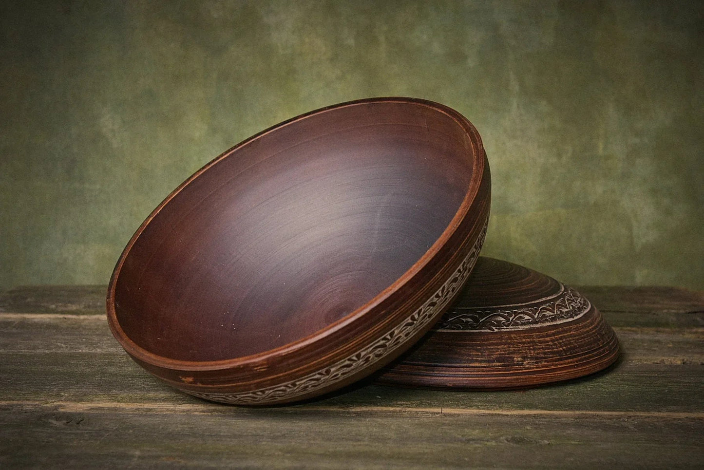 Handmade large ceramic baking dish with lid, engraved clay cauldron on rustic wood surface