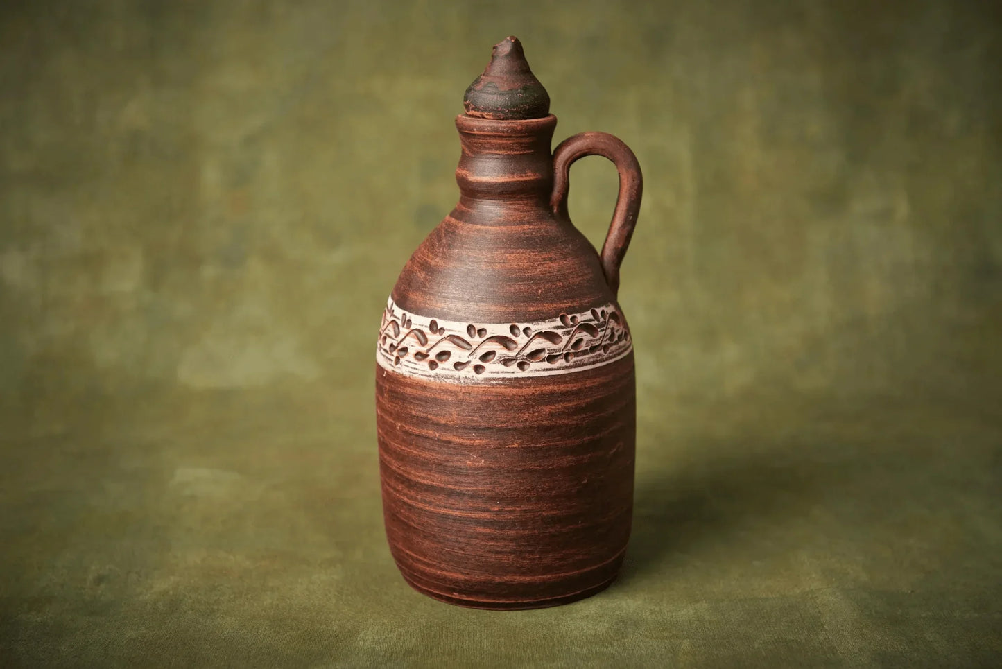 Handmade ceramic amphora-style clay bottle with lid and handle, brown with decorative band