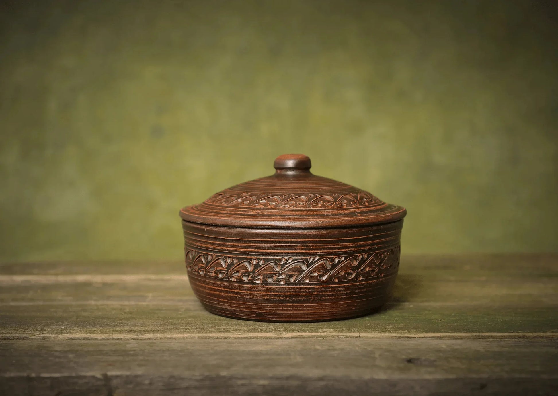 Handmade ceramic bread pot with lid, artisan clay bakeware on rustic wood table