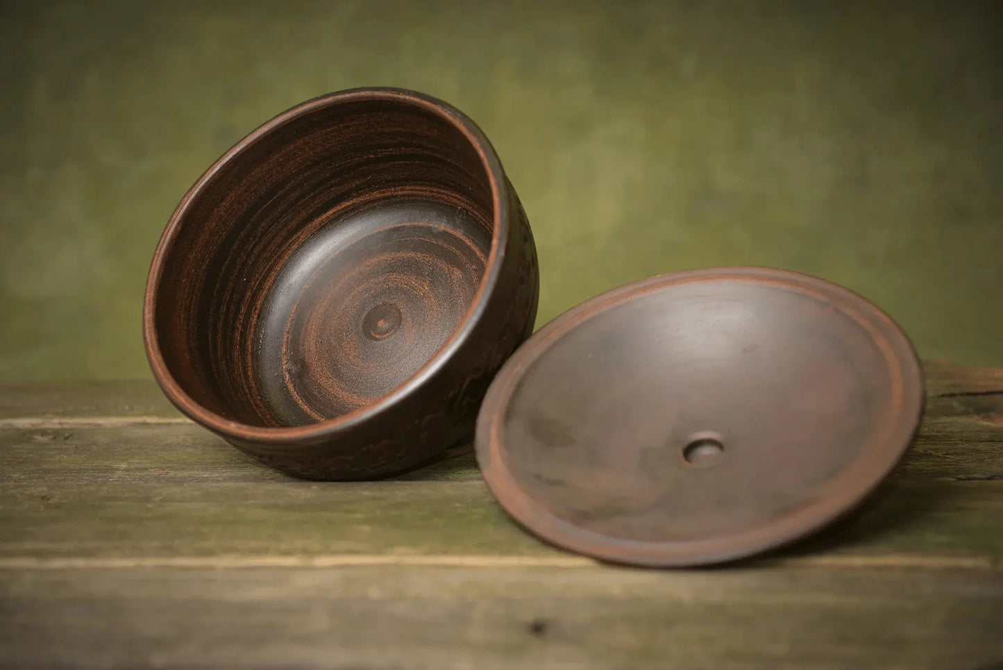 Handmade ceramic bread pot with matching lid on rustic wood, artisan clay bakeware