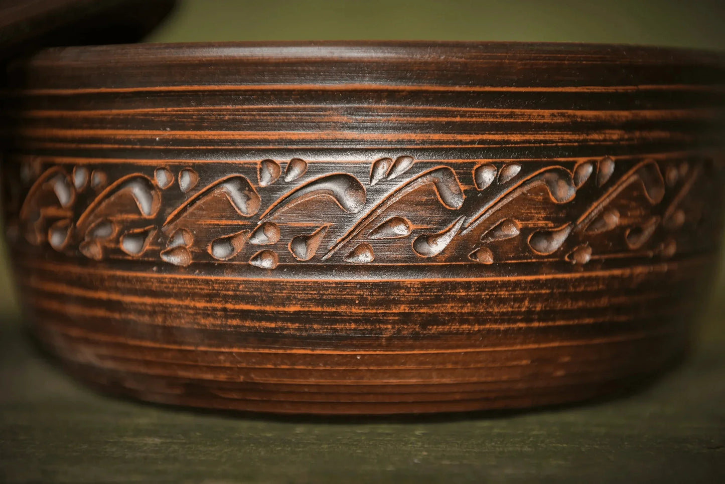 Handmade clay bread pot with lid and decorative carved vine pattern, artisan ceramic bakeware