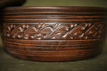 Handmade clay bread pot with lid and decorative carved vine pattern, artisan ceramic bakeware