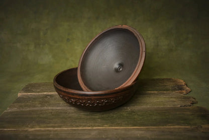Handmade ceramic clay cooking pot with lid, round oven-safe baking dish on rustic wood