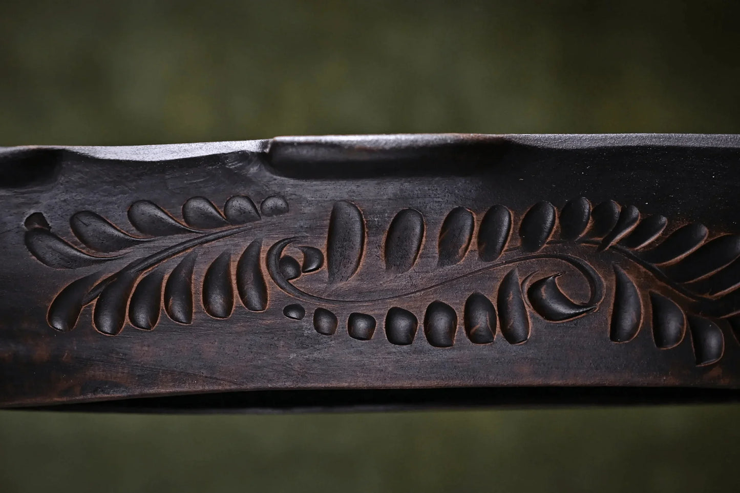 Handmade dark clay pottery plate with carved leaf pattern, artisan home décor product
