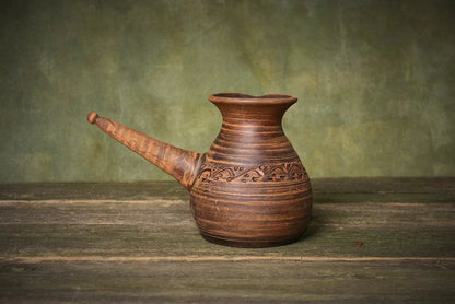 Handmade red clay cezve coffee pot with handle, artisan organic pottery on wood table