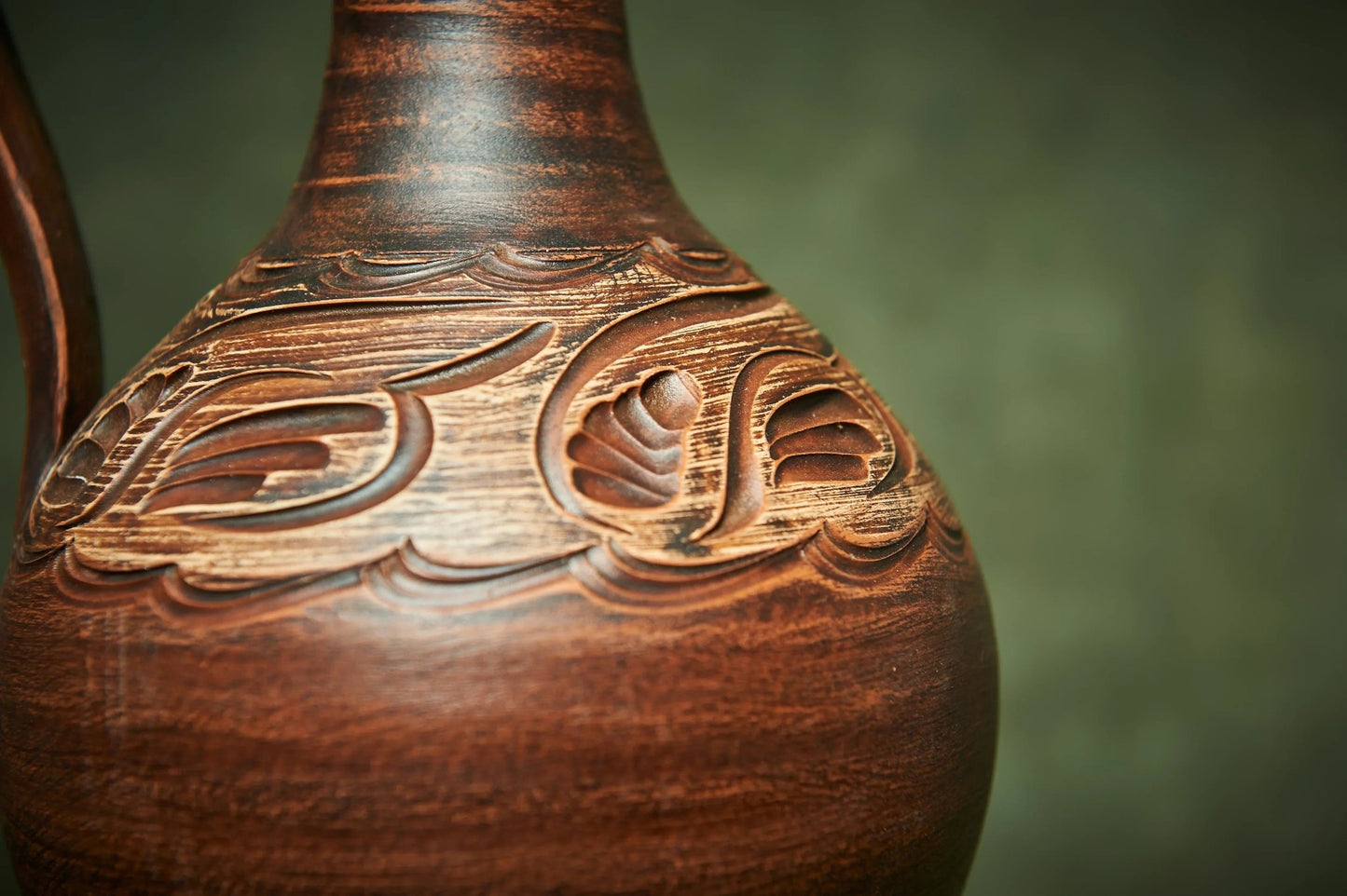 Handmade ceramic pitcher with intricate carved pattern, artisan clay home decor