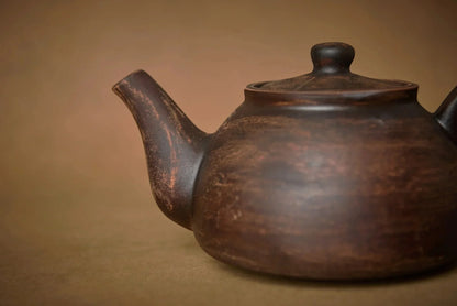 Handmade ceramic teapot with rustic finish, artisan pottery, brown clay teaware