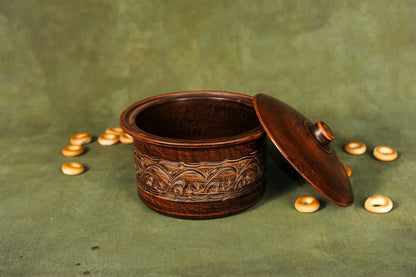 Handmade clay pot bread baking pan with lid and decorative pattern on green background