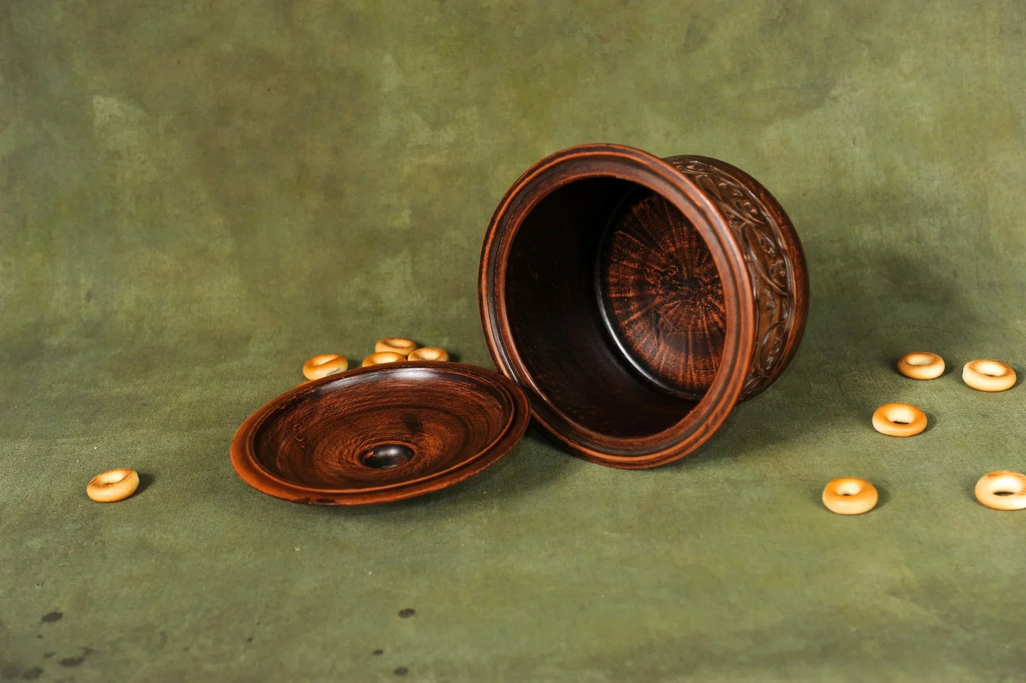 Handmade clay pot with lid, artisan ceramic bread baking pan on green background