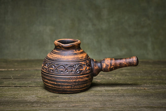 Handmade clay pot with carved floral design, rustic brown finish, artisan-crafted homeware for home décor