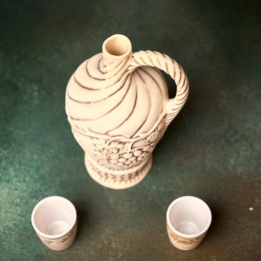 Handmade clay sake set with carved pitcher and two cups, artisan-crafted for home décor