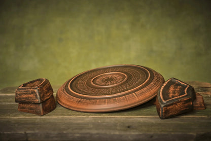 Handmade ceramic serving plate and clay bowls on rustic wood, artisan homeware décor
