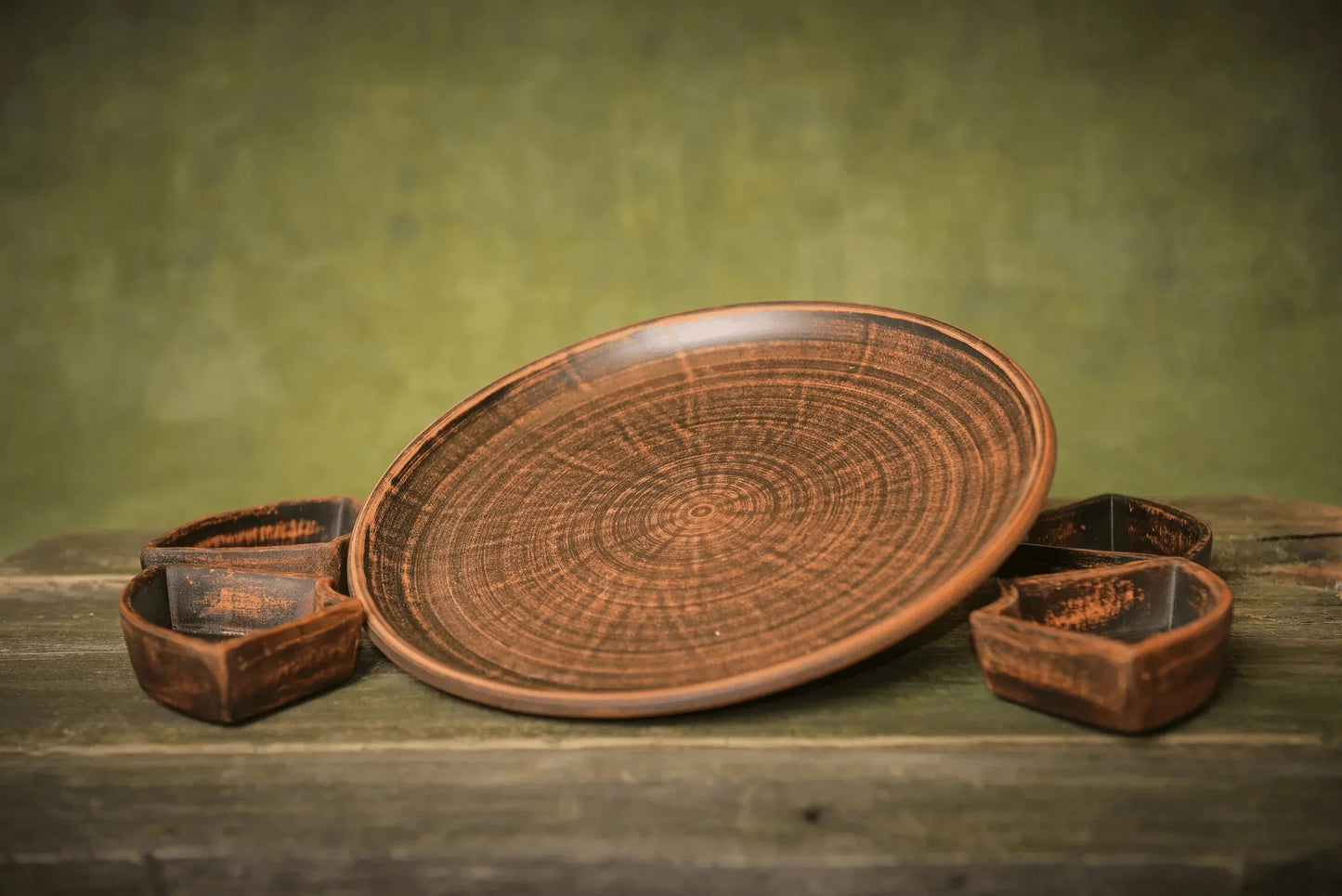 Handmade ceramic serving tray with rustic clay bowls on a wooden surface, artisan homeware