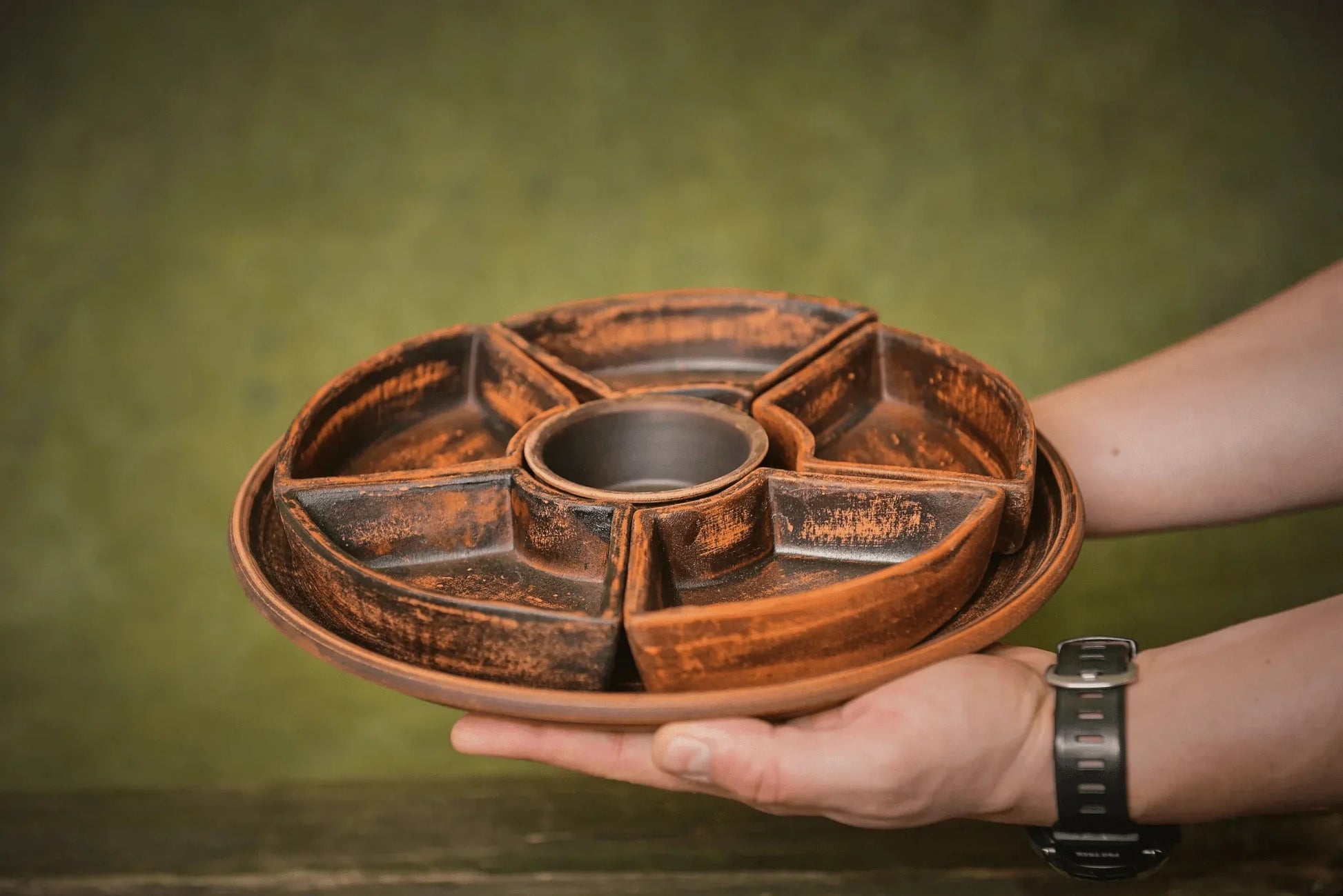 Hand holding a handmade ceramic serving tray with separate clay compartments, artisan homeware