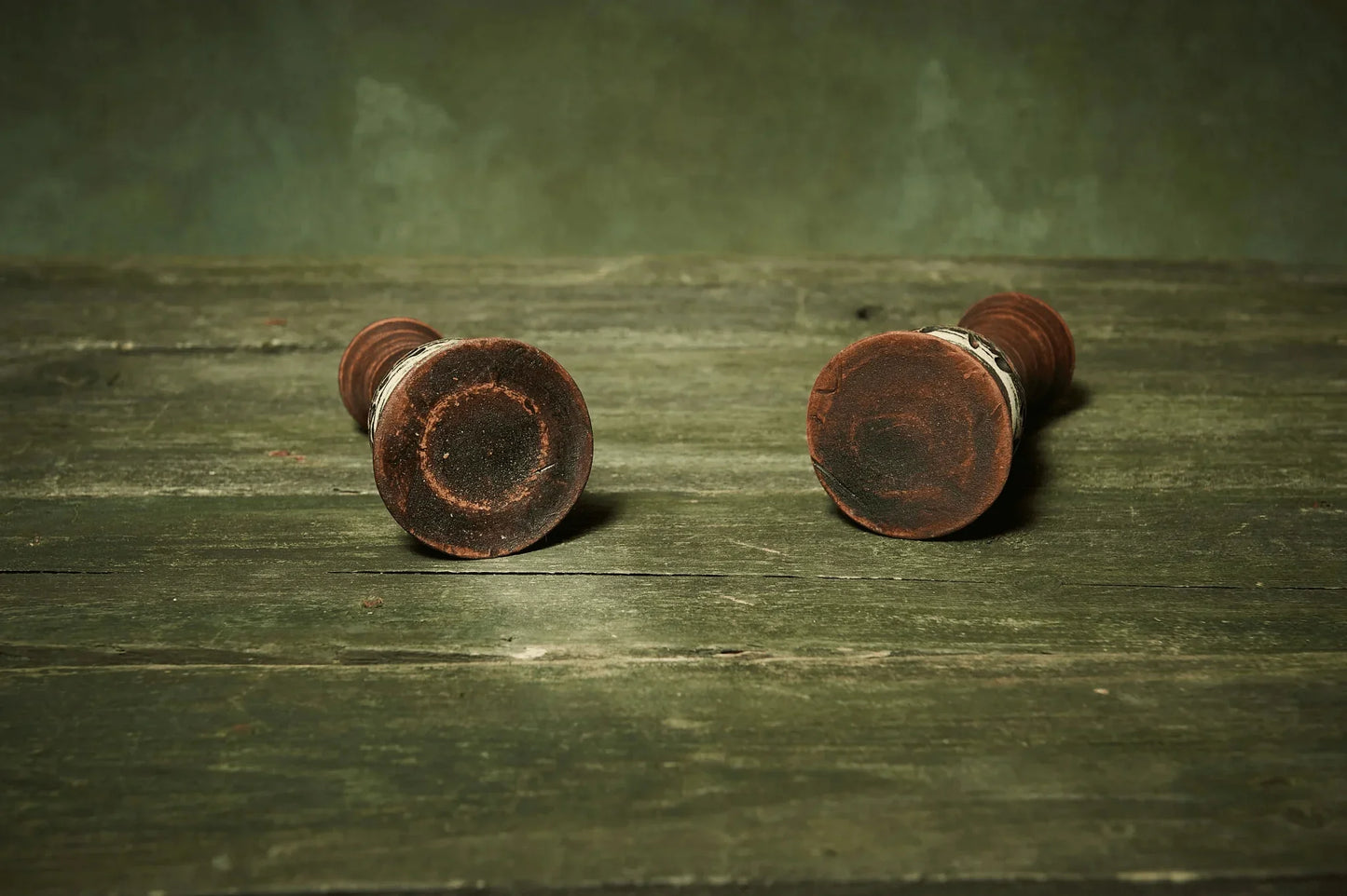 Set of two handmade ceramic candlestick holders on rustic green wooden table