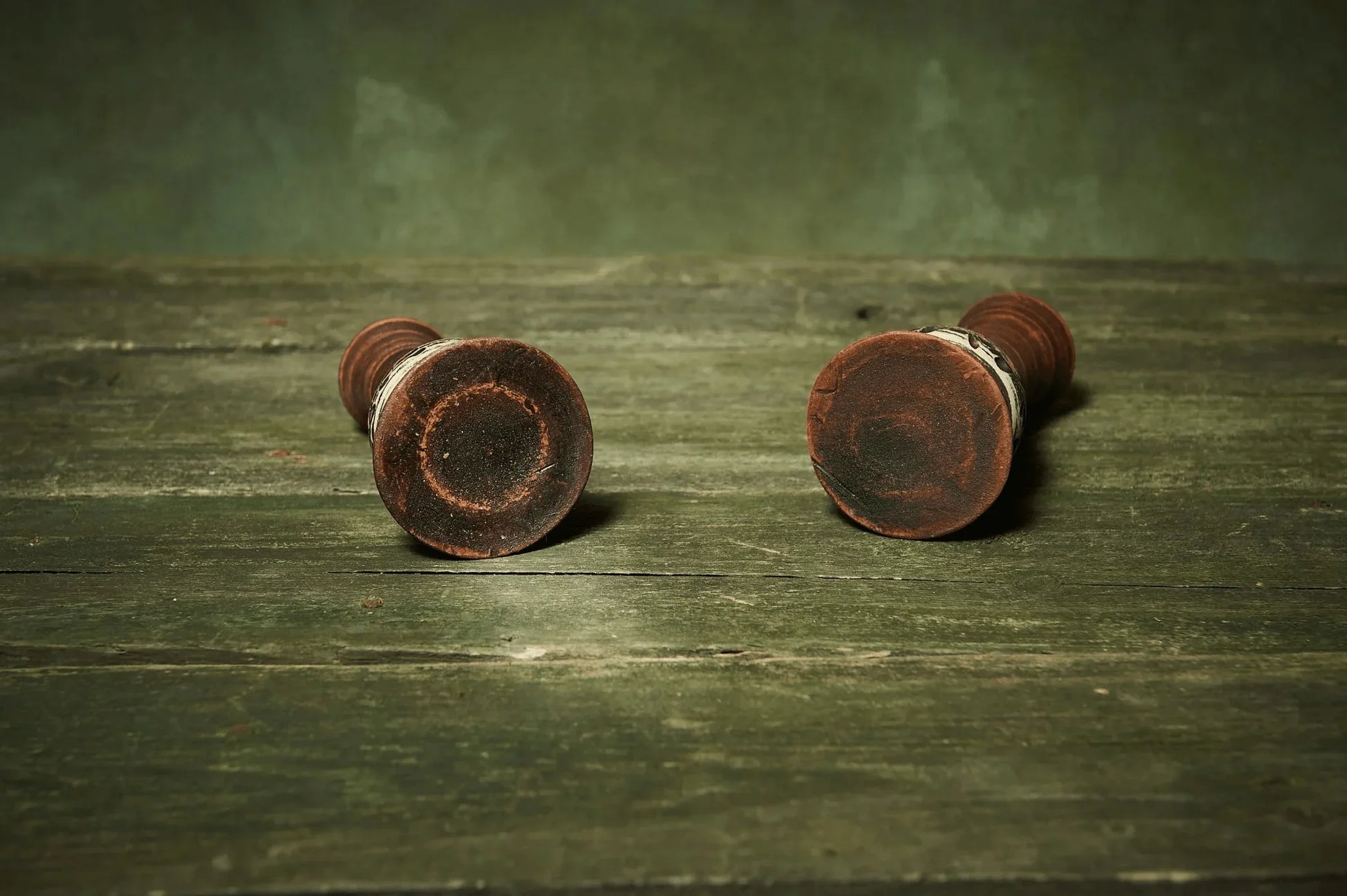 Set of two handmade ceramic candlestick holders on rustic green wooden table