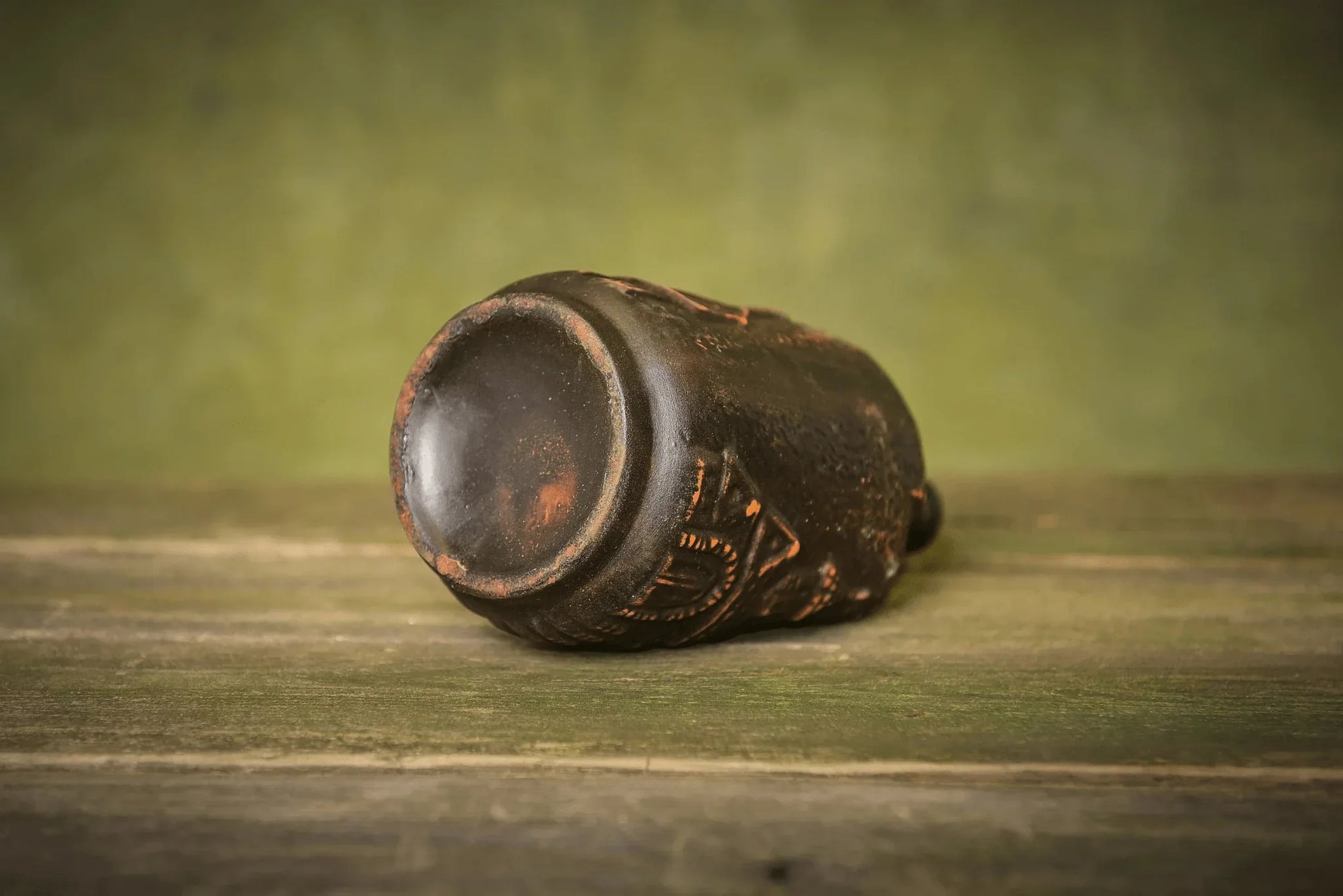 Handmade small ceramic bottle with rustic clay texture on wooden surface, artisan home decor