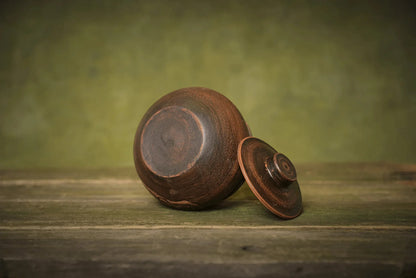Handmade ceramic sugar bowl with lid, rustic brown stoneware on wooden surface