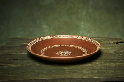 Handmade ceramic fruit plate with intricate patterns, large pottery serving platter on rustic wood