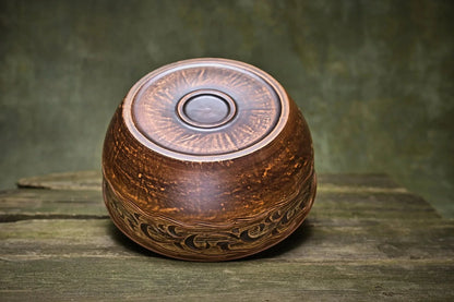 Handmade Ukrainian ceramic pot with lid, rustic brown glaze, artisan pottery on wood surface