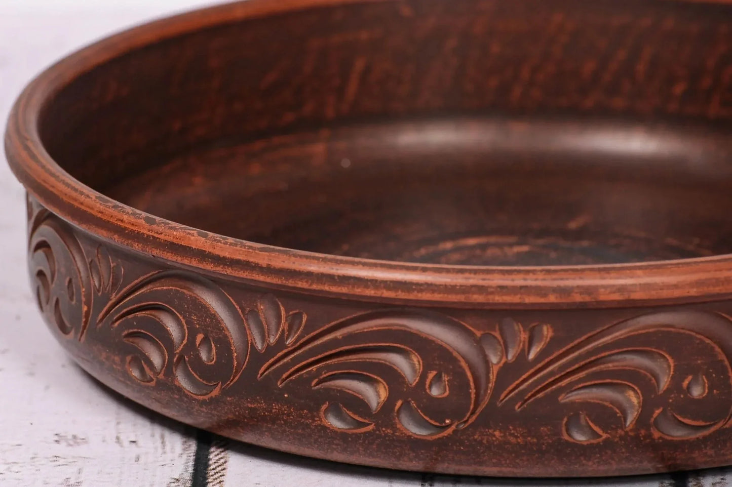 Handcrafted round ceramic baking dish with ornate clay design, artisan pottery homeware