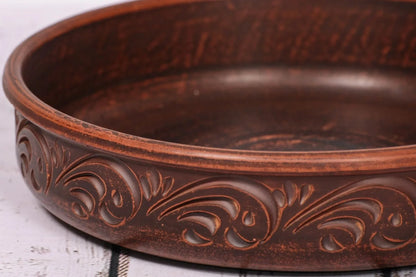 Handcrafted round ceramic baking dish with ornate clay design, artisan pottery homeware