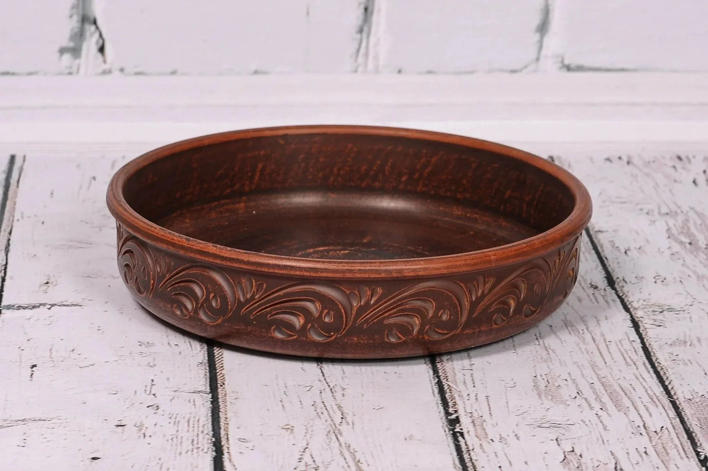 Handcrafted round ceramic baking dish with decorative patterns, artisan clay homeware