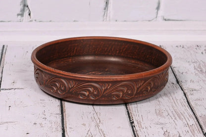 Handcrafted round ceramic baking dish with decorative patterns, artisan clay homeware