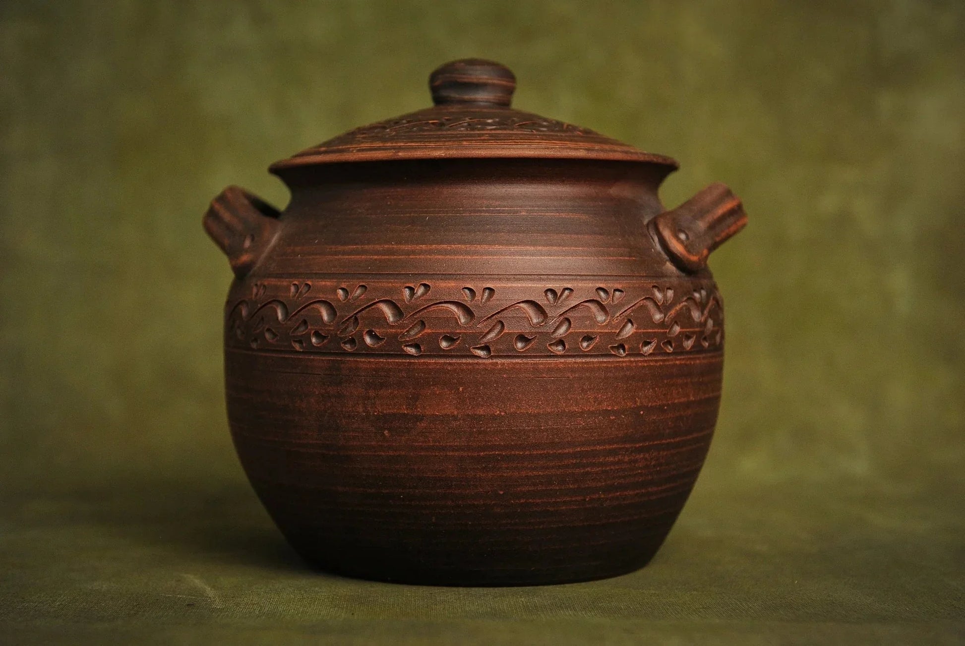 Handmade ceramic baking pot with lid and handles, rustic brown clay kitchenware