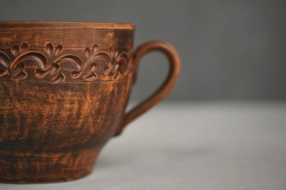 Handmade clay bowl with handle and carved leaf design, artisan Ukrainian pottery