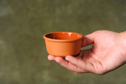 Hand holding handmade terracotta clay bowl, small pottery homeware from clayproductsshop