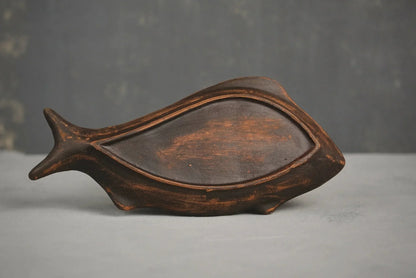 Handcrafted ceramic fish-shaped clay plate with rustic brown finish on grey background