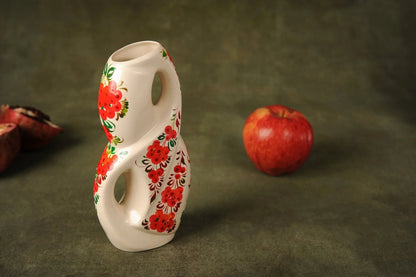 Handmade white ceramic vase with red floral design, unique home decor on table