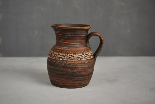 Handmade ceramic milk pitcher with carved floral design, artisan home decor jug
