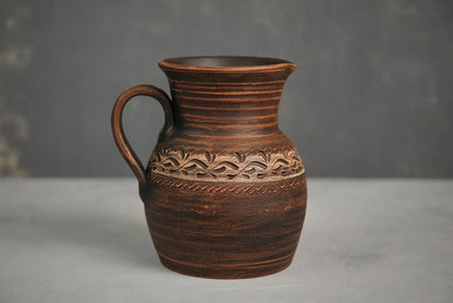 Handmade ceramic milk pitcher with engraved floral pattern, artisan clay homeware