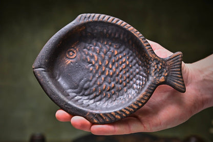 Hand holding handmade clay fish-shaped plate, rustic pottery homeware from clayproductsshop