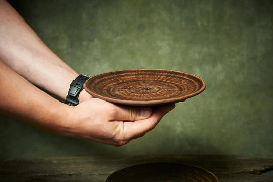 Handmade brown ceramic plate held in hands, artisan pottery from clayproductsshop