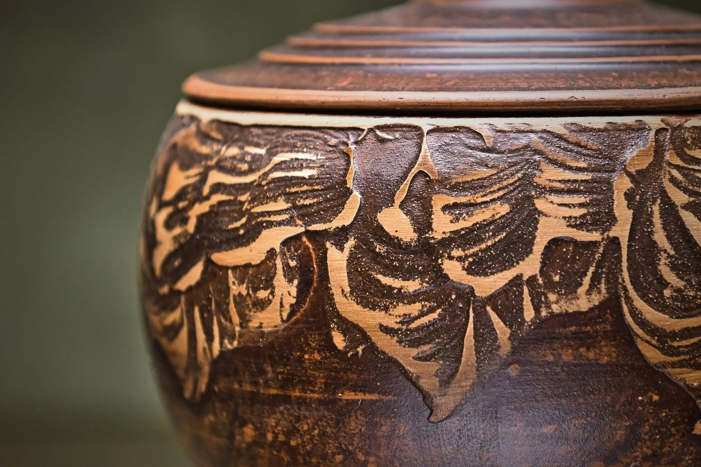 Handmade clay pot with carved floral pattern and matching lid, artisan homeware