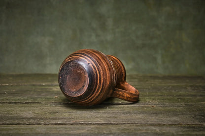 Handmade clay creamer jug with rustic brown finish on wooden surface, artisan pottery homeware