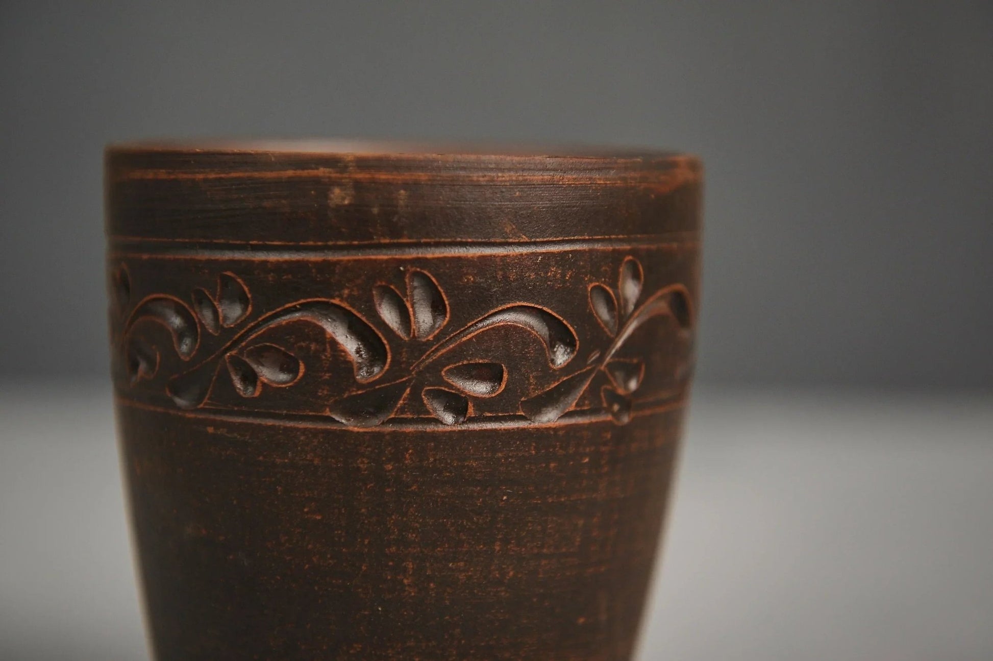 Hand-engraved red clay ceramic glass with decorative vine detail, artisan homeware