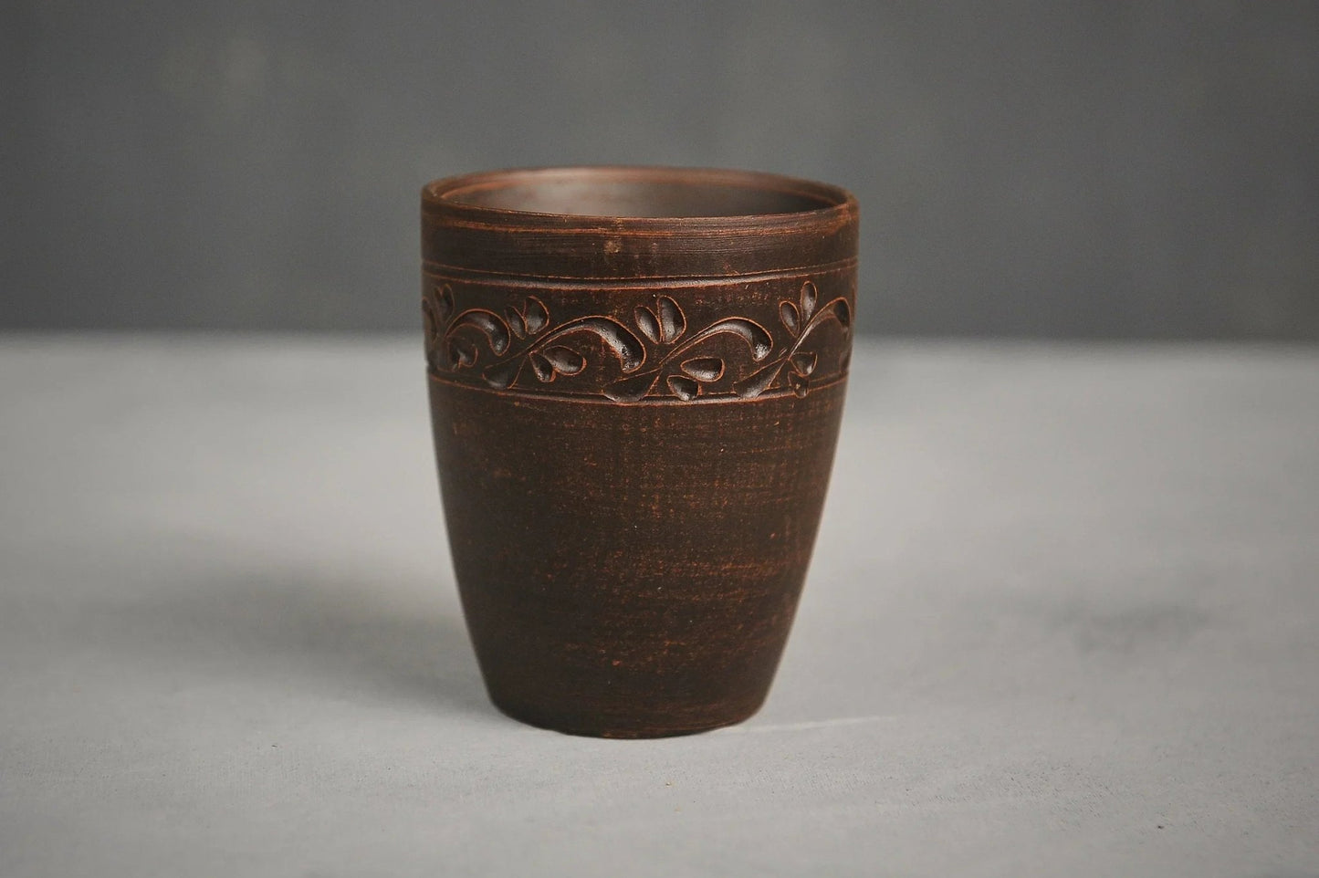 Hand-engraved ceramic drinking glass made of red clay with leaf motif, artisan homeware
